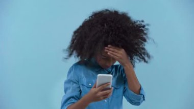 Afro-Amerikalı çocuk mavi hattan izole edilmiş akıllı telefon kullanıyor. 