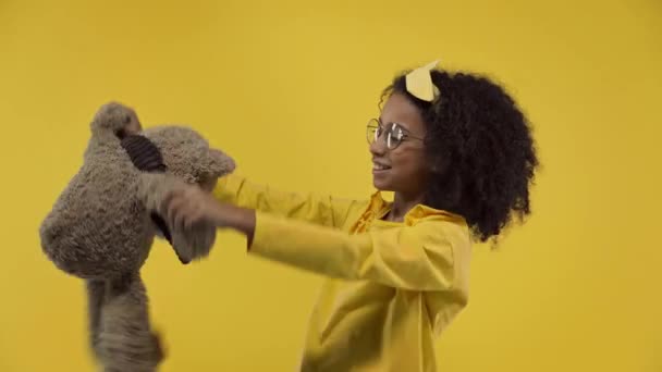 Afrikanisch Amerikanisches Kind Spielt Mit Teddybär Isoliert Auf Gelb — Stockvideo