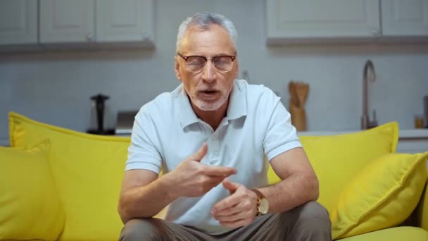 Senior Man Glasögon Gestikulerar Och Talar Vardagsrummet — Stockvideo