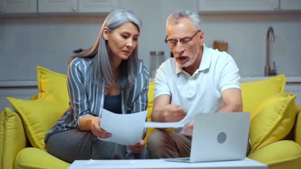 Unzufriedenes Senioren Ehepaar Schaut Auf Scheine Der Nähe Von Laptop — Stockvideo