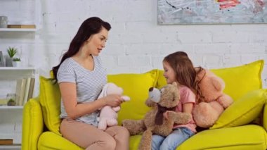 Mutlu anne ve çocuk yumuşak oyuncaklarla oynuyor. 