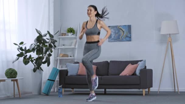 自宅でトレーニングをしながら その場で実行しているスポーツ女性 — ストック動画