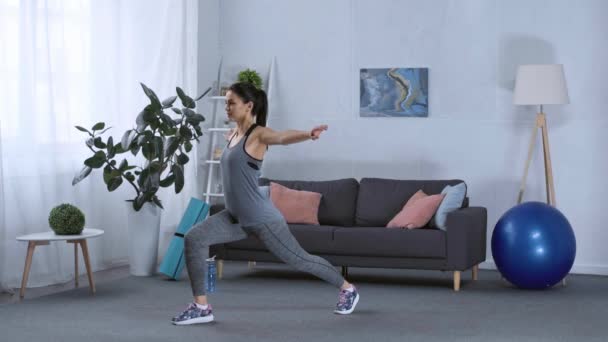 Side view of sportswoman doing lunge while training at home — Stock Footage Side View Sportswoman Doing Lunge While Training Home Video Clip