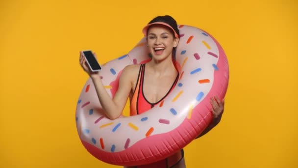 Chica Alegre Con Anillo Goma Hablando Teléfono Inteligente Aislado Amarillo — Vídeo de stock