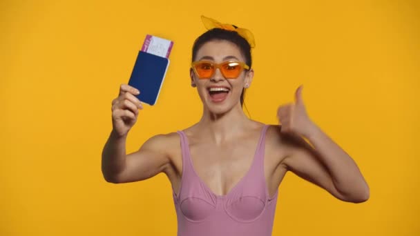 Щаслива Дівчина Купальнику Вказує Паспорт Авіаквиток Ізольовано Жовтому — стокове відео
