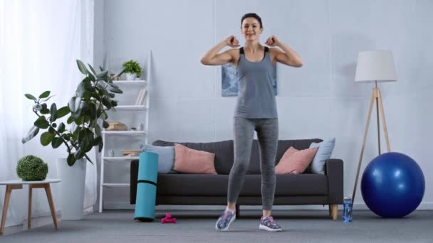 自宅でスポーツ用品の近くに笑みを浮かべてスポーツ女性のトレーニング — ストック動画
