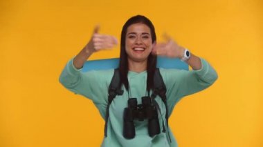 Gülümseyen gezgin birini arıyor ve sarı renkte elleri ile işaret ediyor.