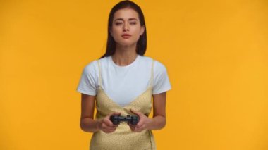 KYIV, UKRAINE - 3 Mart 2020: Endişeli kız sarı üzerine izole edilmiş olarak oyun oynuyor ve joystick fırlatıyor