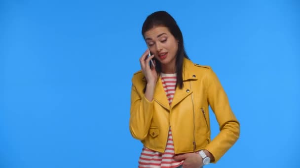 Šťastná Dívka Žluté Bundě Mluví Smartphone Izolované Modré — Stock video
