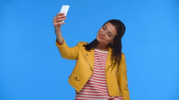 漂亮的女人用蓝色隔离的智能手机自拍 — 图库视频影像
