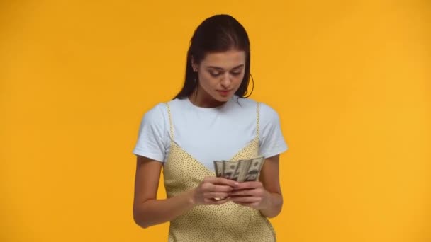 Χαμογελαστή Κοπέλα Ρίχνει Χαρτονομίσματα Δολαρίου Απομονωμένα Στο Κίτρινο — Αρχείο Βίντεο