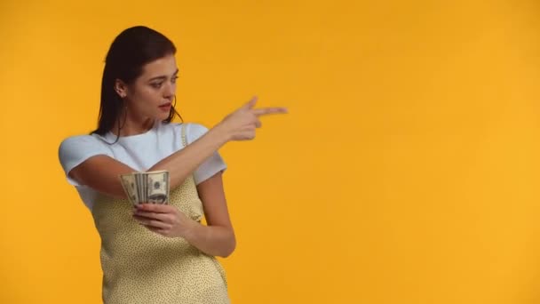 Menina Bonita Apontando Com Dedo Notas Dólar Isolado Amarelo — Vídeo de Stock