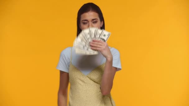 Glimlachende Vrouw Zwaaiend Met Dollarbiljetten Geïsoleerd Geel — Stockvideo