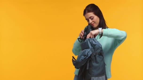 Turista Sorrindo Colocando Binóculos Mochila Isolada Amarelo — Vídeo de Stock