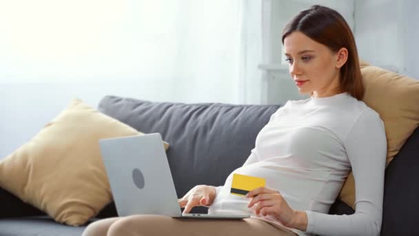 Sorrindo Menina Grávida Com Cartão Crédito Laptop Sofá — Vídeo de Stock