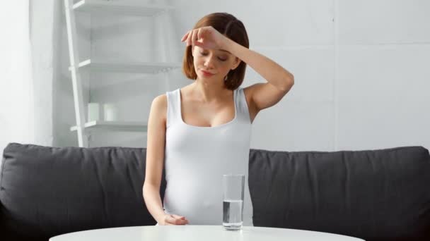 Schwangere Nimmt Pille Mit Wasser Auf Der Heimischen Couch — Stockvideo