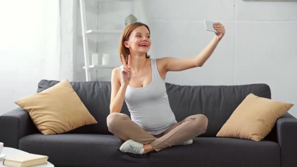 Mujer Embarazada Feliz Tomando Selfie Con Teléfono Inteligente Sofá — Vídeo de stock