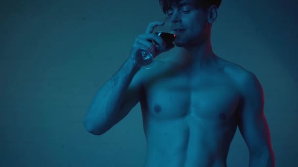 Rack Focus Muscular Man Drinking Wine Blue — Stock Video