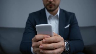 Akıllı telefondan mesajlaşan işadamının kırpılmış görünümü 