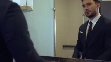 Banyodaki aynaya bakan mutlu iş adamı 