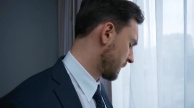 Stresli takım elbiseli iş adamı otelde akıllı telefonla konuşuyor. 