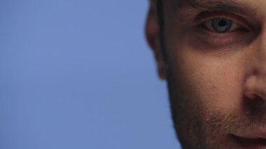 Mavi üzerine izole edilmiş kameraya bakan bir adam görüntüsü.