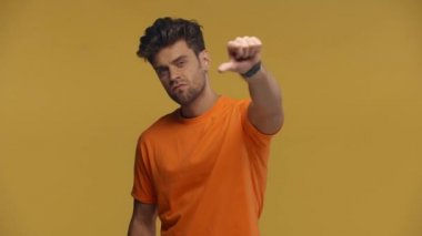 Sinirli bir adam sarı kameraya işaret ediyor ve işaret ediyor.