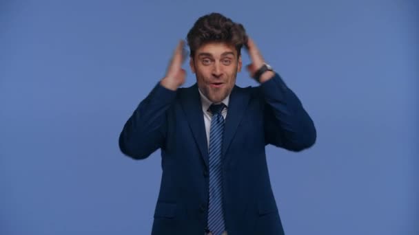 Шокированный Бизнесмен Показывающий Большие Пальцы Камеру Изолированную Голубом — стоковое видео
