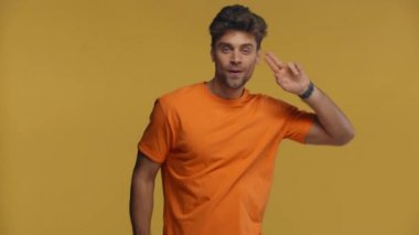 Mutlu adam dans ediyor ve sarı renkli kameraya bakıyor.