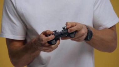 KYIV, UKRAINE - 26 Şubat 2020: Sarı üzerinde izole edilmiş video oyunu oynayan adamın kırpılmış görüntüsü