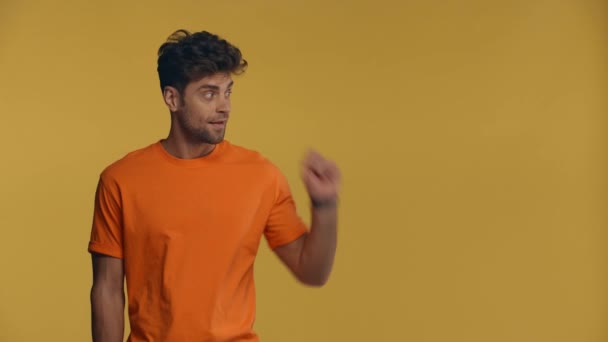 Usmívající Muž Ukazuje Prstem Izolovaným Žluté — Stock video