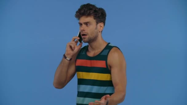 Homem Irritado Falando Smartphone Mostrando Dedo Médio Isolado Azul — Vídeo de Stock