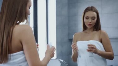 Banyo havlusuyla dişlerini fırçalamaya hazırlanan çekici bir kadın. 