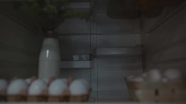Delikanlı buzdolabından süt alıyor.
