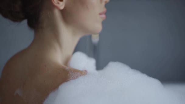 バブルバスで洗う魅力的な若い女性の姿を間近で見ることができます — ストック動画