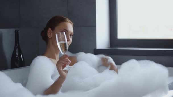 Attrayant Jeune Femme Couché Dans Bain Moussant Sirotant Champagne — Video