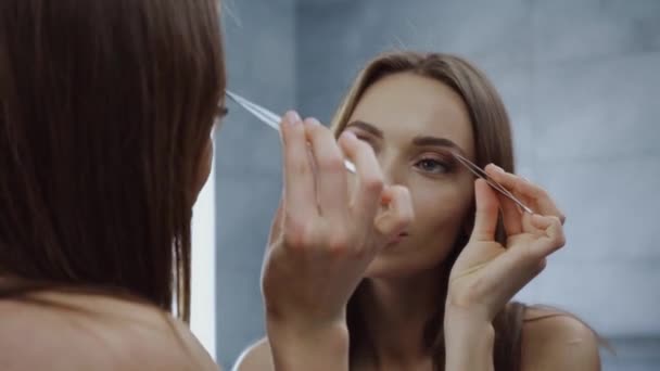 Hermosa Joven Mujer Arrancando Las Cejas Con Pinzas Baño — Vídeo de stock