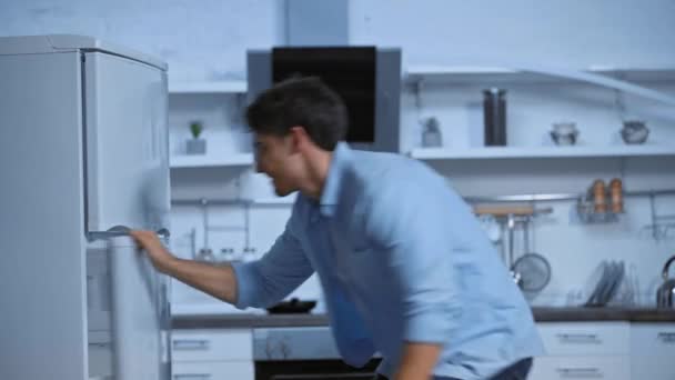 Displeased Man Blue Shirt Looking Fridge Modern Kitchen — Stock Video