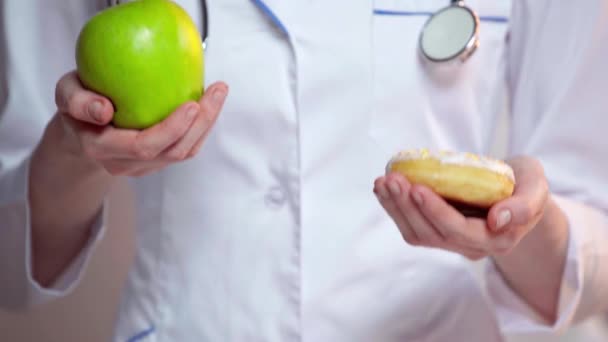 Ausgeschnittene Ansicht Des Arztes Mit Apfel Und Donut Auf Grauem — Stockvideo