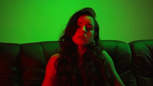 有诱惑力的女孩坐在沙发上 用绿色触摸身体 — 图库视频影像