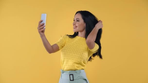Mujer Atractiva Tomando Selfie Con Smartphone Aislado Amarillo — Vídeo de stock
