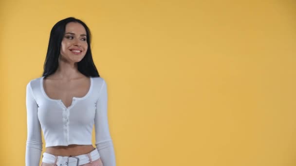 Hermosa Mujer Sonriente Señalando Con Dedo Aislado Amarillo — Vídeo de stock