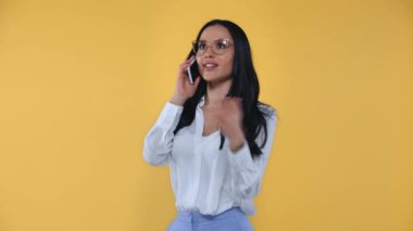 İş kadınından çıkmış, sarı telefonda konuşurken el kol hareketi yapıyor.