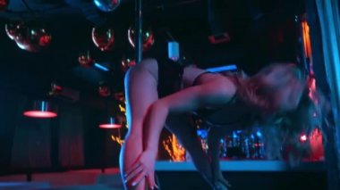 Striptiz kulübünde direğin yanında dans eden seksi kadın. 