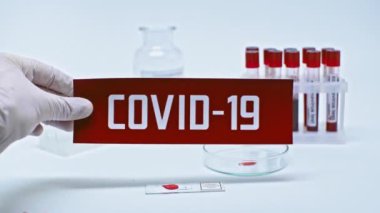 Laboratuvarda CV19 kartı tutan bilim adamının kırpılmış görüntüsü
