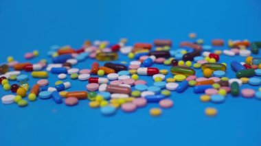 Mavi yüzeydeki renkli hapların seçici odak noktası