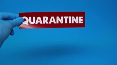 Mavi üzerinde karantina kartı olan lateks eldivenli bir erkeğin kısmi görüntüsü