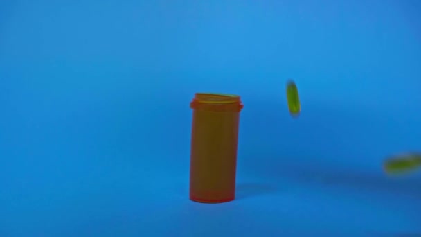 Pillen Fallen Neben Glas Auf Blauem Hintergrund — Stockvideo