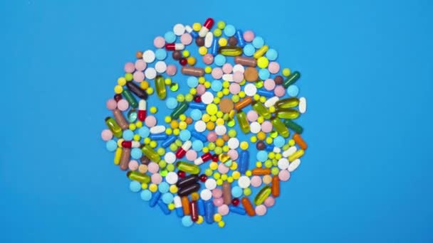 Vue du dessus du médecin mettant des pilules de pot sur fond bleu filant 