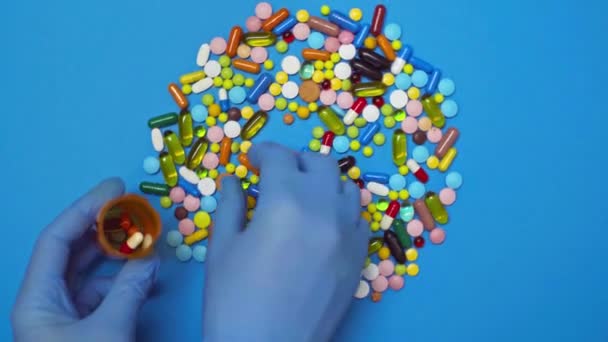トップビューの医師取り丸薬で瓶で回転青の背景 — ストック動画